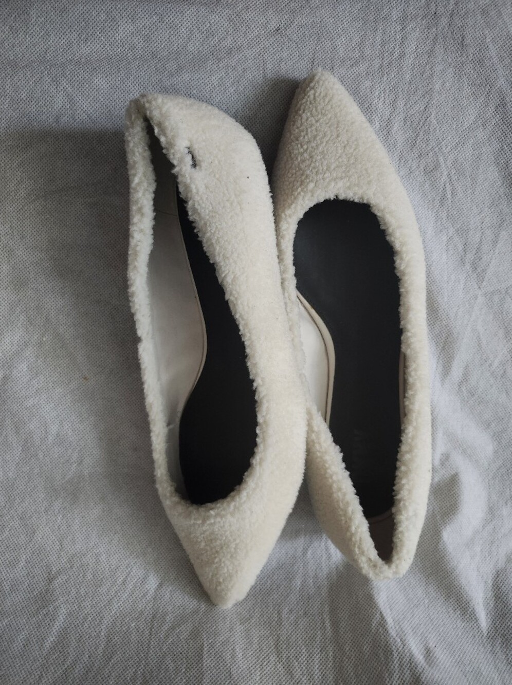 DKNY Women's Pointed Toe Faux-Shearling Flats with Black Soles In White